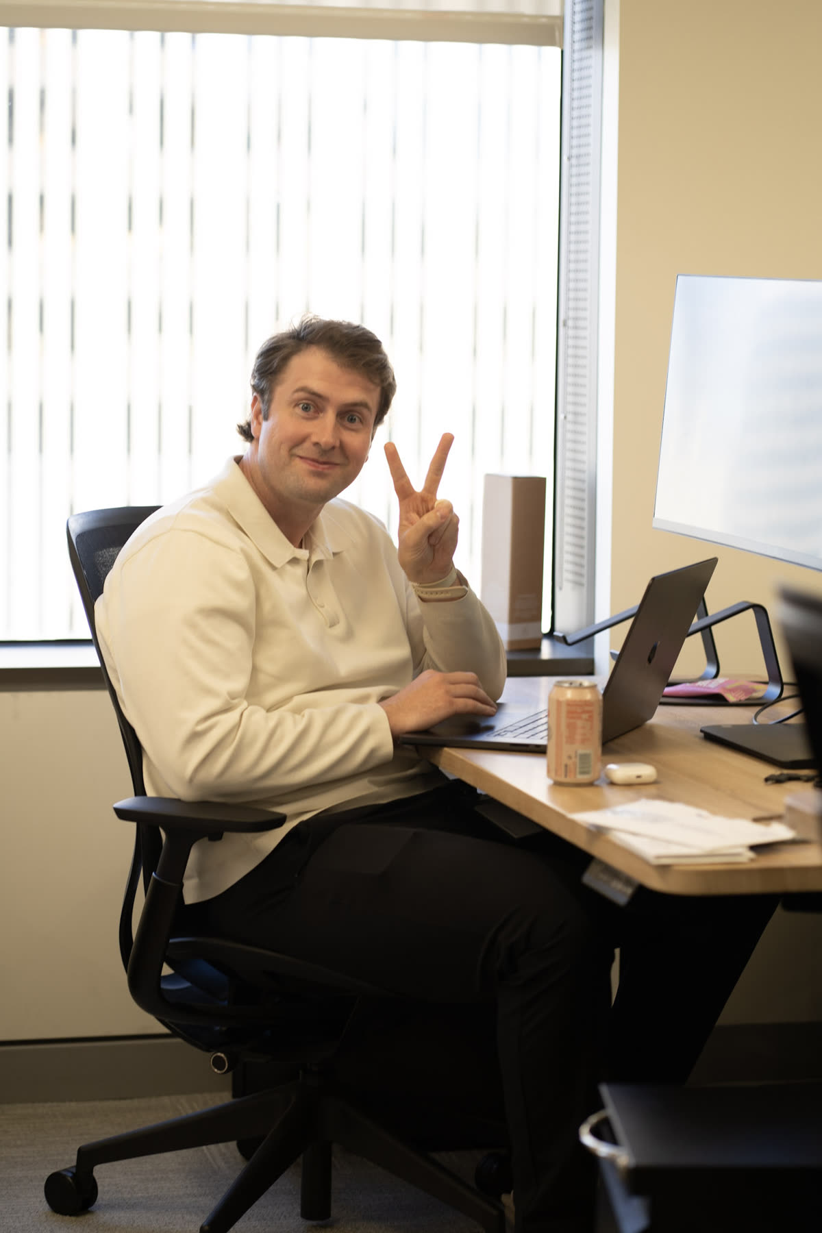 Teammate giving a peace sign at his desk