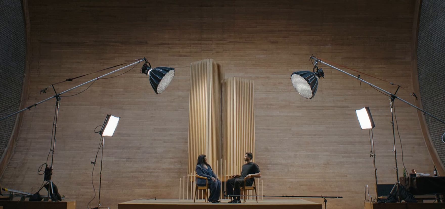 The film set: two chairs between the lights in front of the timber wall